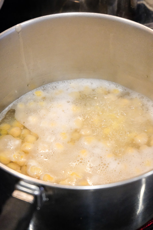 The first step in making hummus is boiling the chickpeas.