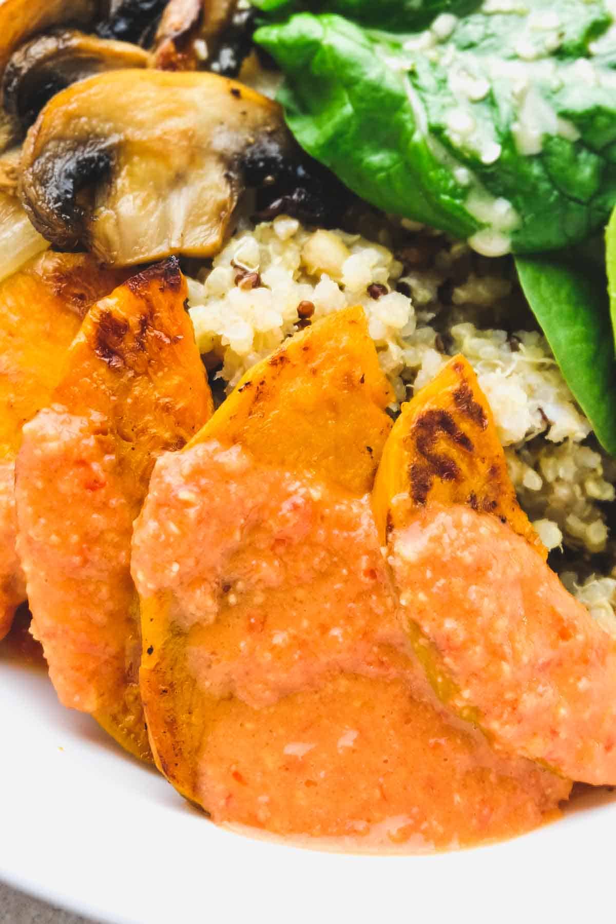 Red pepper miso dressing as a topping for roasted sweet potatoes in a buddha bowl vegan recipe.