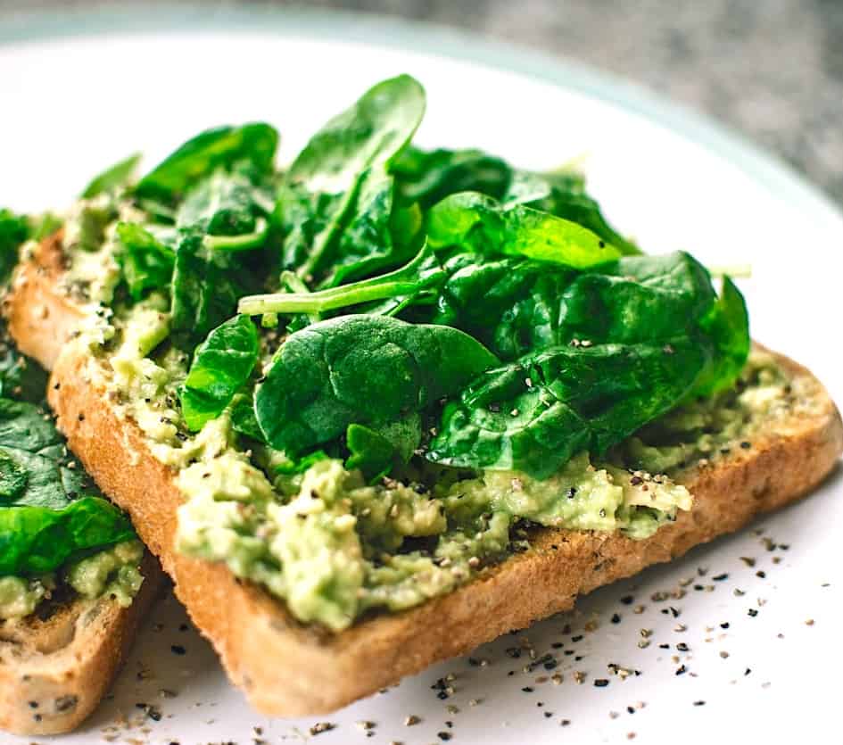 avocado toast topped with fresh basil.