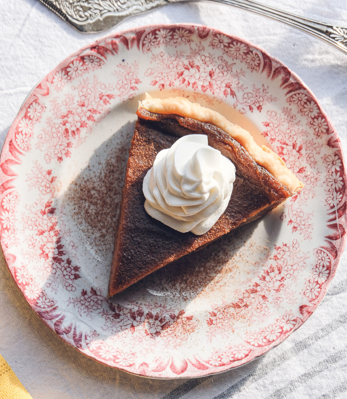 Top-down view of a pumpkin pie on a plate with whipped cream topping.